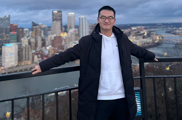 Yufeng Qian with the Pittsburgh skyline in the background