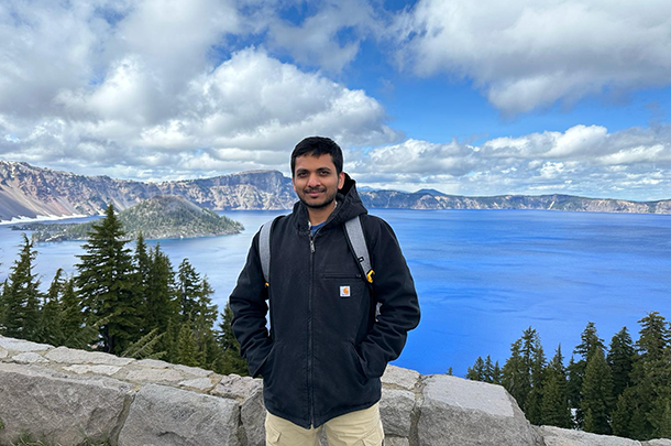 Anchit Singhal with a lake and snow-covered mountains in the background