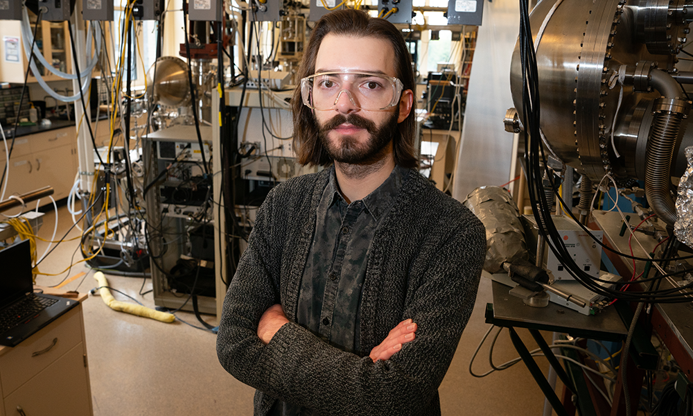 Ian Martin stands with arms folded in a catalysis laboratory full of equipment