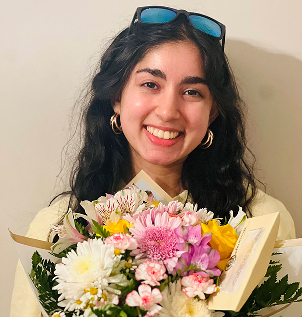 Avineet Nanjappa smiles for the camera while holding a big bouquet of flowers