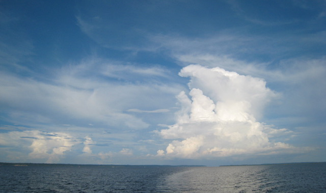 A towering, white storm cloud over the coast of Brazil, seen from the ocean