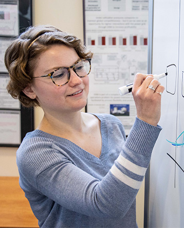 Megan Walsh writes on a dry erase board